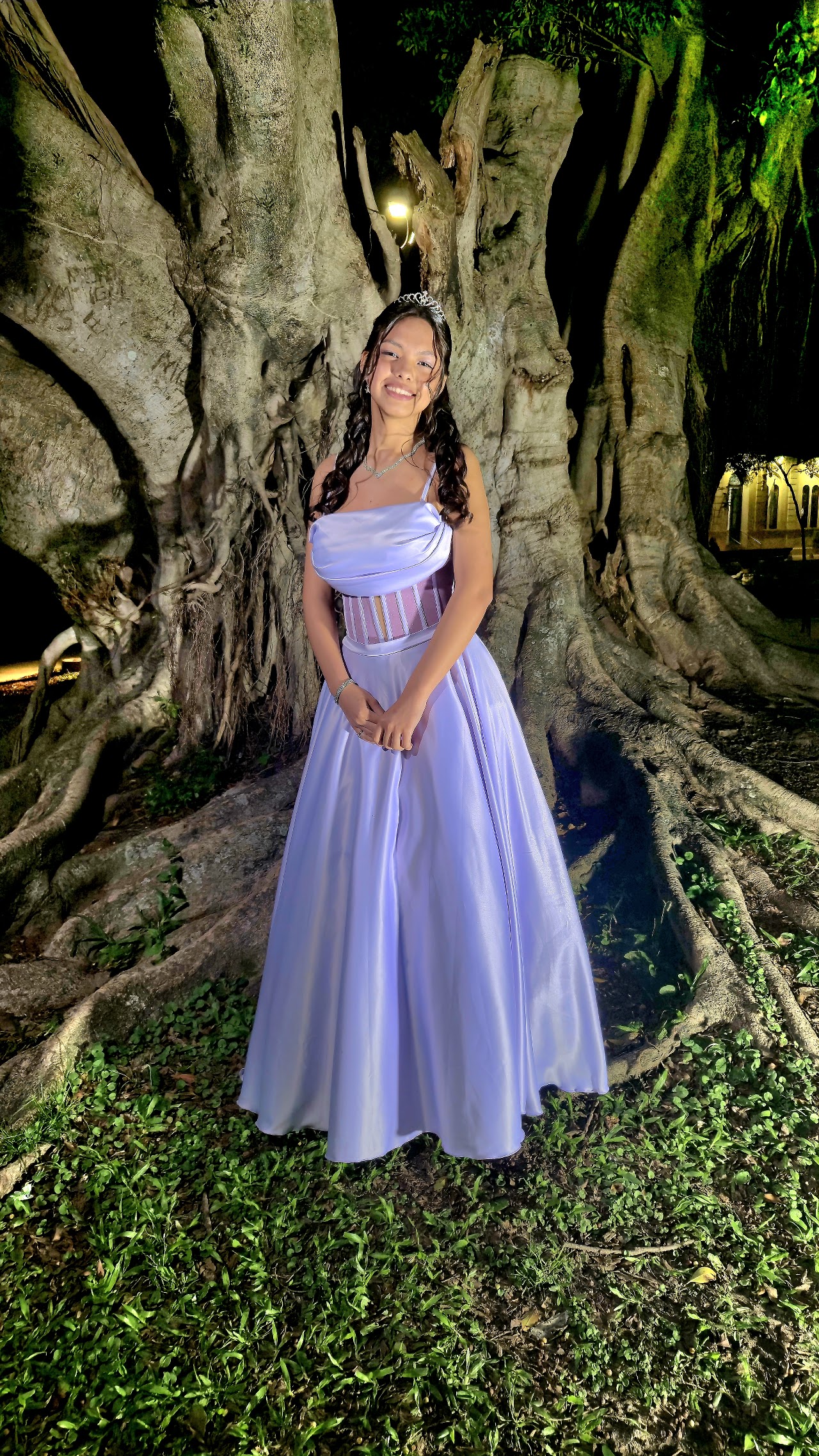 Quinceañera posando al aire libre con vestido de gala